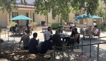 People eating outside in sunny courtyard