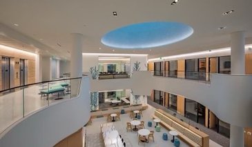 View of the interior of the Chen Neuroscience Research Building from the third floor gallery, it shows the tiled skylight, the third floor elevators, the second floor write up and social areas.