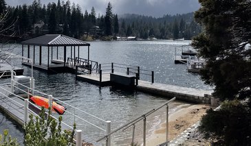 Sunny view of lake, beach and jetty