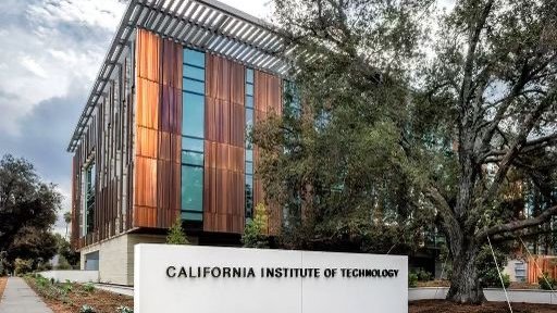 West side view of the Chen Neuroscience Research Building, showing the exterior copper facade, Caltech signage on a white wall next to an oak tree.