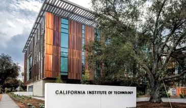 West side view of the Chen Neuroscience Research Building, showing the exterior copper facade, Caltech signage on a white wall next to an oak tree.