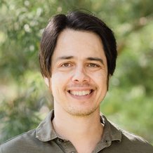 headshot of man with green shirt and brown hair