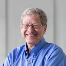 headshot of man with glasses and blue shirt