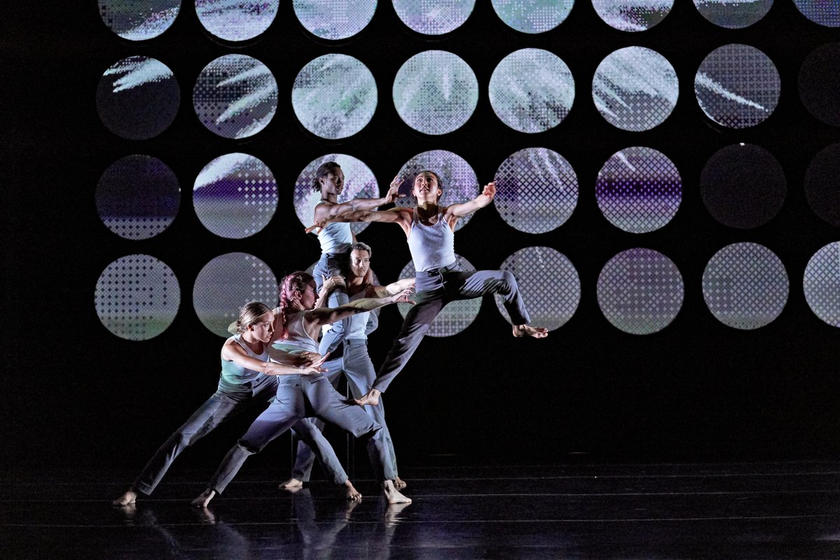A contemporary dance troupe performing on stage