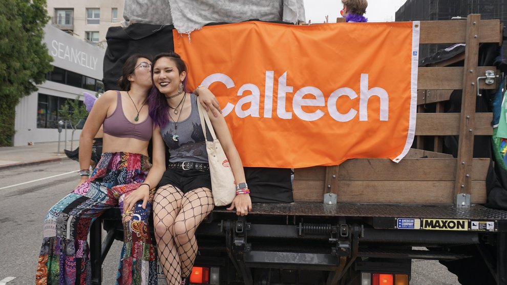 Undergraduates Zara Kanold-Tso (left) and Maven Holst (right) sit on the back of the Caltech float.
