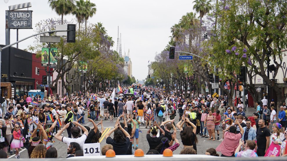 Caltech dancers lead the float while a crowd cheers them on.
