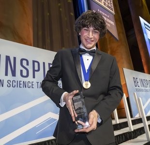 2025 Regeneron Science Talent Search first-place winner Matteo Paz holds his trophy