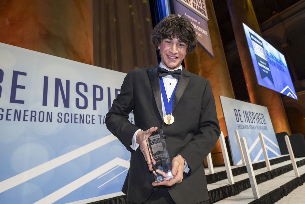 2025 Regeneron Science Talent Search first-place winner Matteo Paz holds his trophy