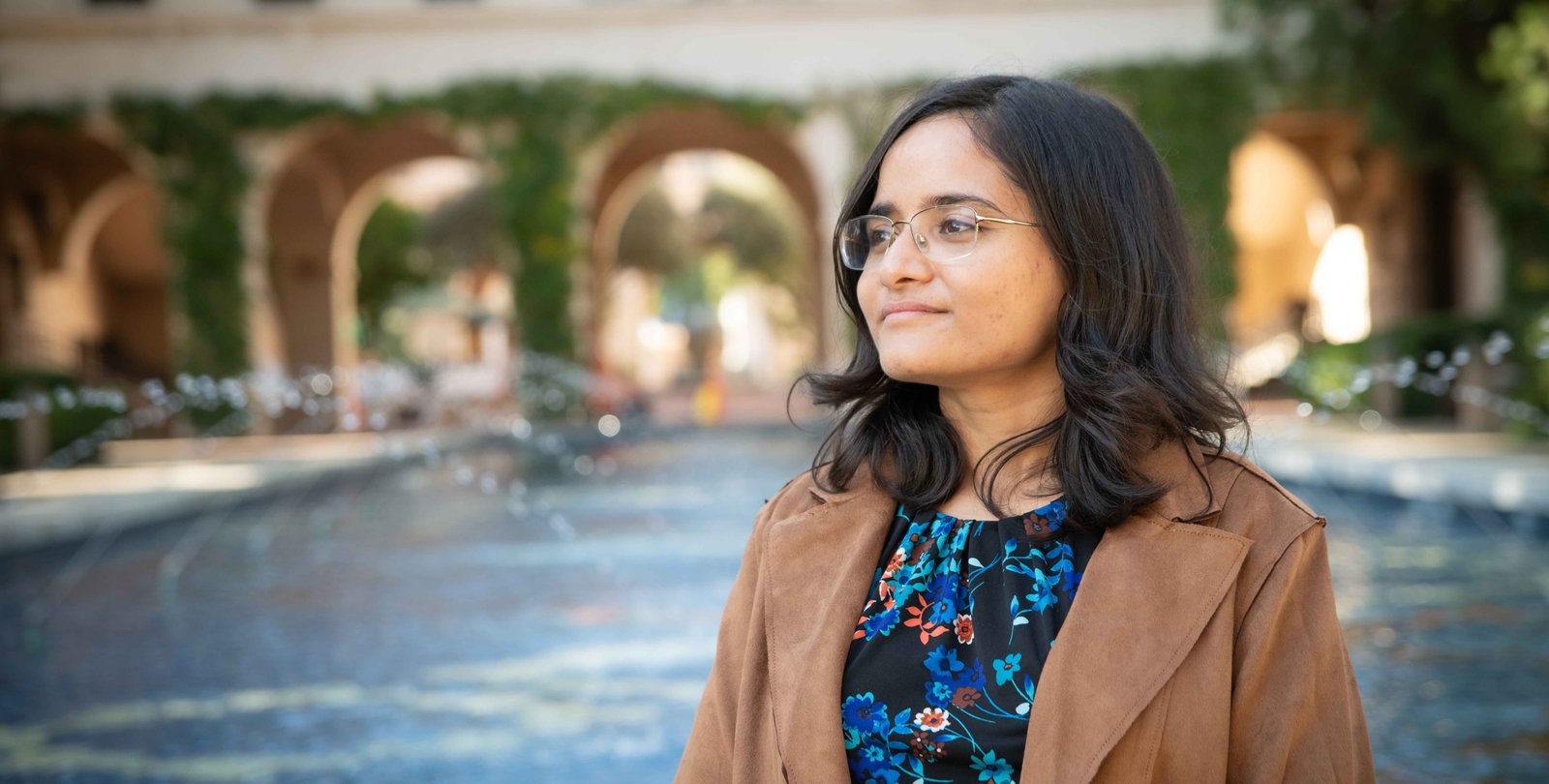 Person looking into the distance with a fountain in the background