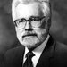 Profile of Arden Albee, wearing a jacket and tie, with white hair and beard.