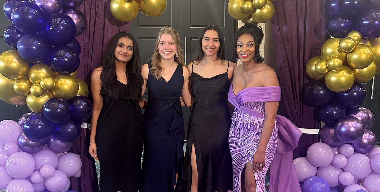 Caltech student tutors (left to right) Tisya Rawat, Miina Anvelt, and Gabi Twombly join SGV-NCNW President Marie Thermidor (right), surrounded by a purple and gold balloon arrangement