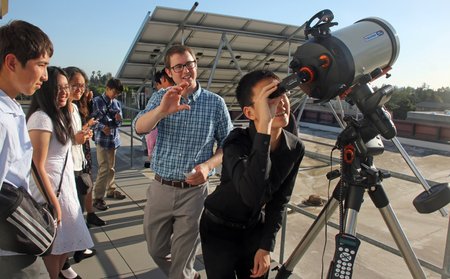 Garreth Ruane, a postdoctoral scholar in astronomy, shows visiting students from South Pasadena High School filtered views of the sun.