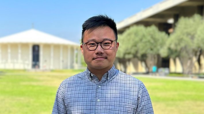 Peiwei Chen stands before the Beckman Auditorium on the Caltech campus.