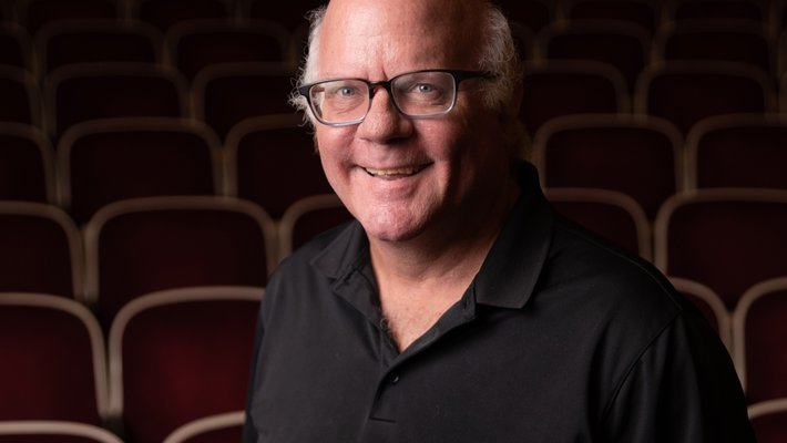 Colin Camerer shown inside Beckman Auditorium, looking at the camera
