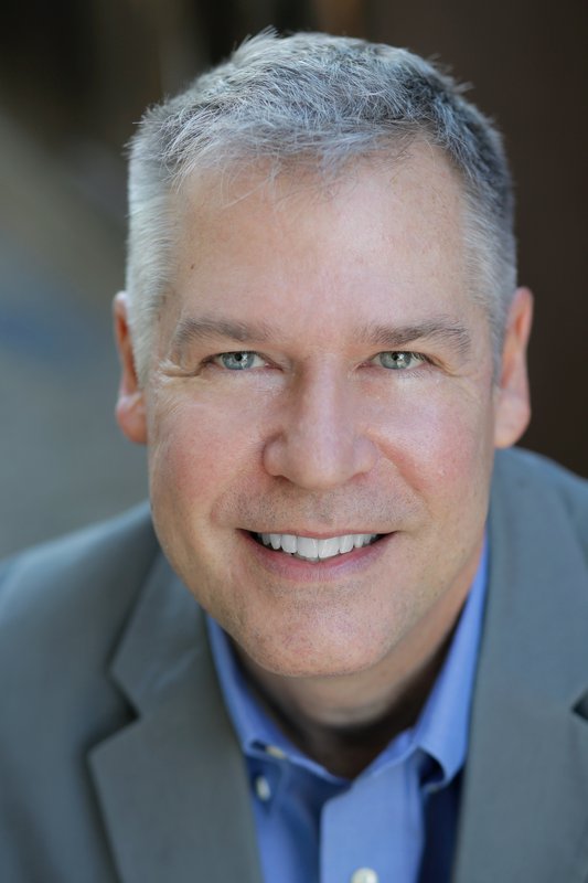 David Warren wearing gray jacket and blue collared shirt