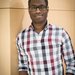 A person in a checkered shirt and glasses