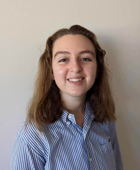 A person in a blue shirt smiles for a photo