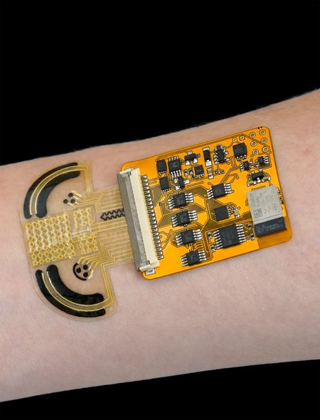 A thin U=shaped device worn on the wrist to detect substances in sweat, with an attached board of computer circuits.