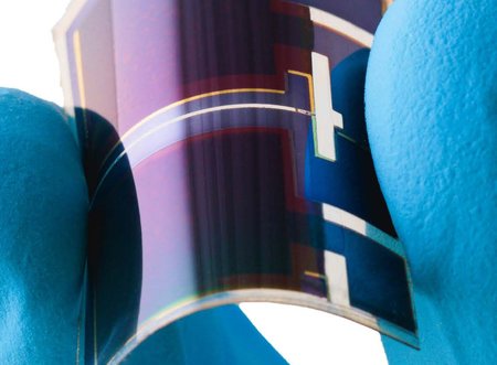 fingers hold a small flexible solar cell