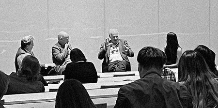 panel of four speakers at a campus event with audience members in foreground