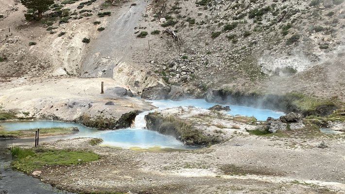 A hillside with steaming pools of water