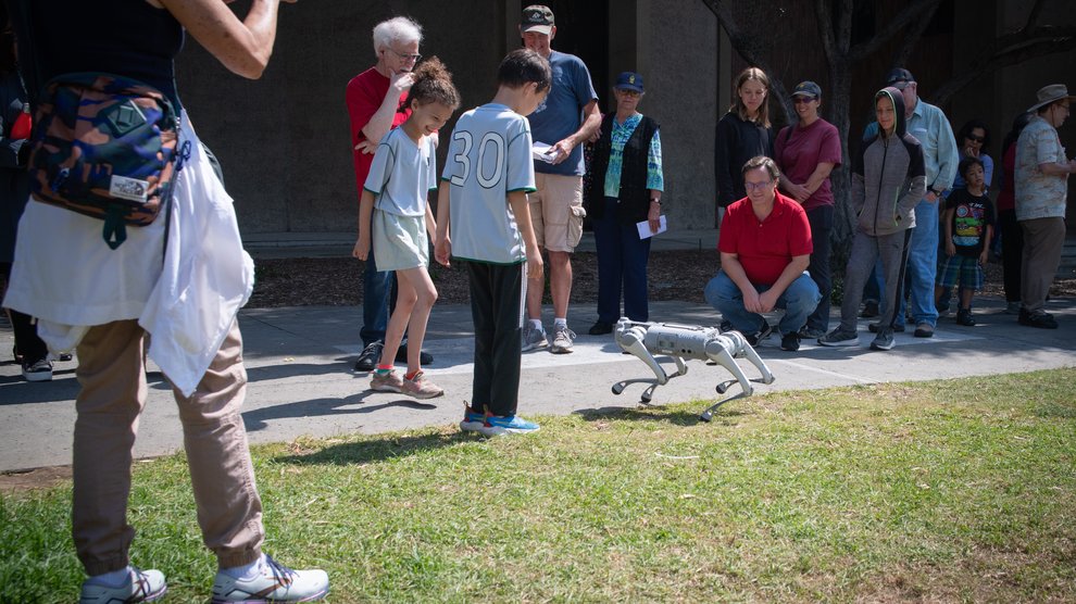 Guests interact with the Unitree Quadruped robot from Caltech's Autonomous Robotics and Control Lab before the show.