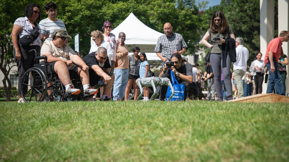 Guests interact with the Unitree Quadruped robot.