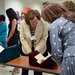 photo of people perusing some of The Huntington's materials from the time period in which Austen's novels were set.