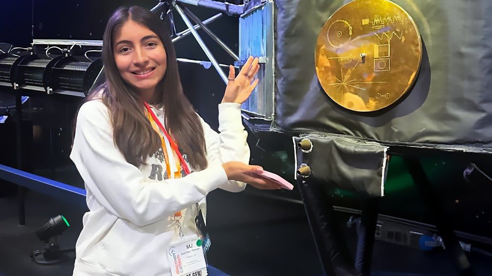 A person poses with a golden record