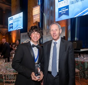Regeneron Science Talent Search winner Matteo Paz and Caltech president Thomas Rosenbaum stand smiling together at a formal event