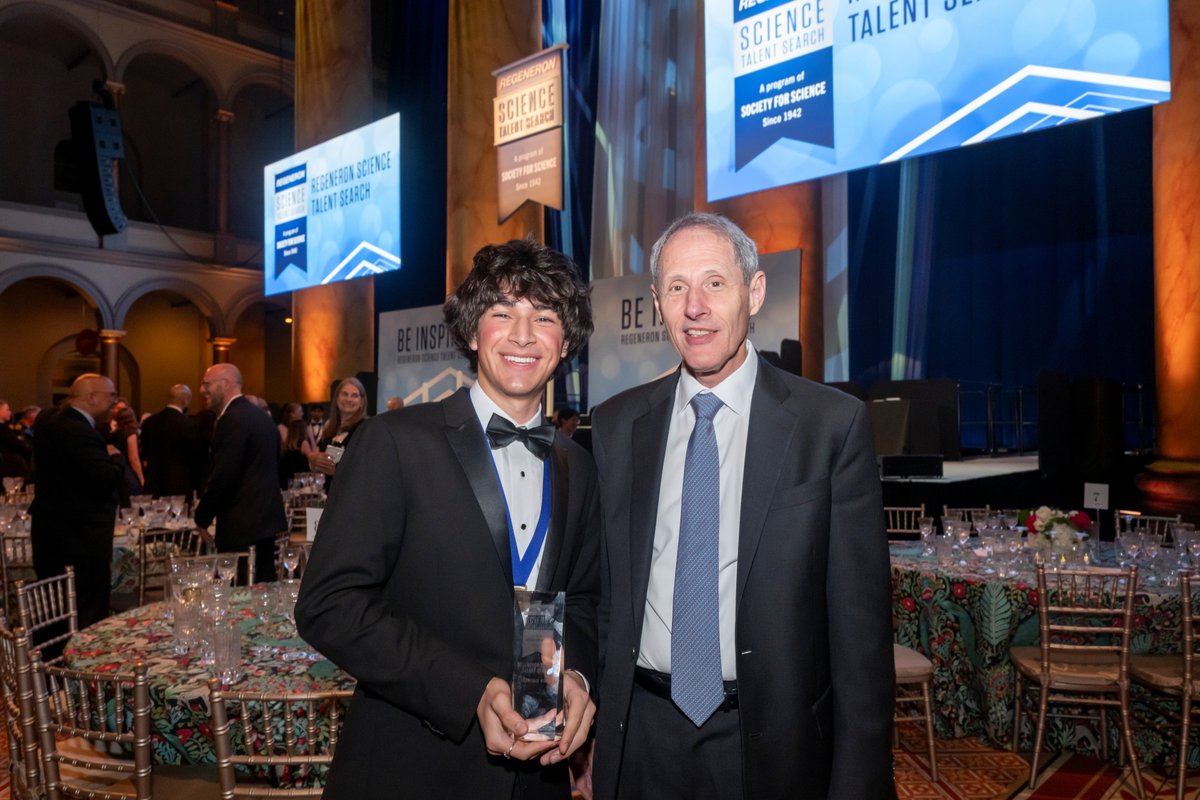 Regeneron Science Talent Search winner Matteo Paz and Caltech president Thomas Rosenbaum stand smiling together at a formal event