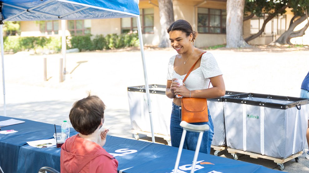 A person stands behind a check-in table.