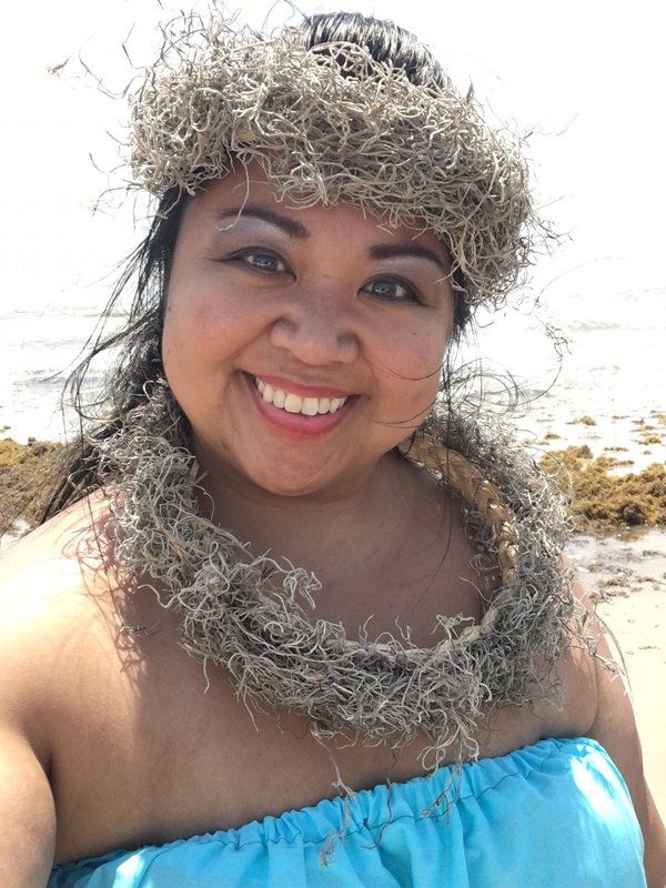 A headshot of Nikki Chun with a beach scene in the background.