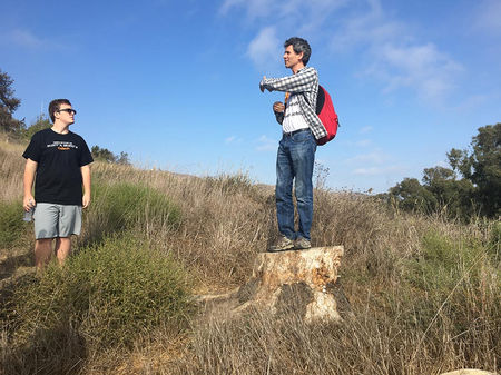 Paul Asimow, the Eleanor and John R. McMillan Professor of Geology and Geochemistry, talks to students from atop a stump during the Frosh Camp geology hike.
