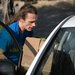 Roman Korol loads cardboard boxes of humanitarian aid into his car.