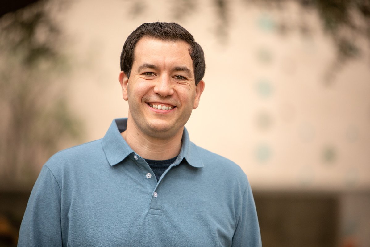 a portrait of Chip Sebens, a middle-aged man in a blue shirt with dark hair