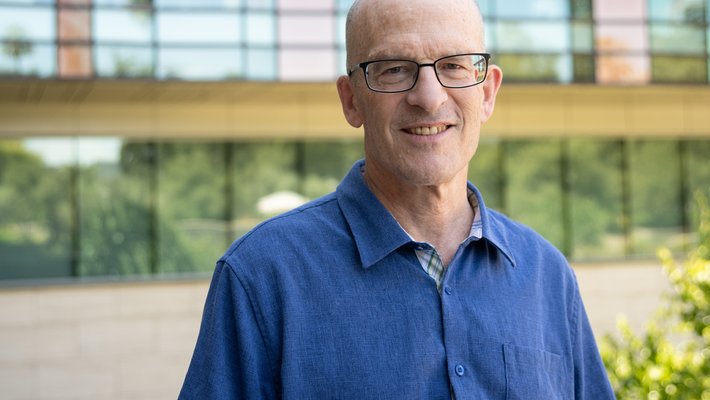 A man with a blue shirt outside of a Caltech building