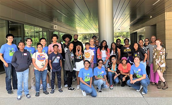 People gather, smiling, for a group photo