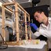 a student works with a tabletop instrument built in the lab with lots of tubing, gauges, and pumps