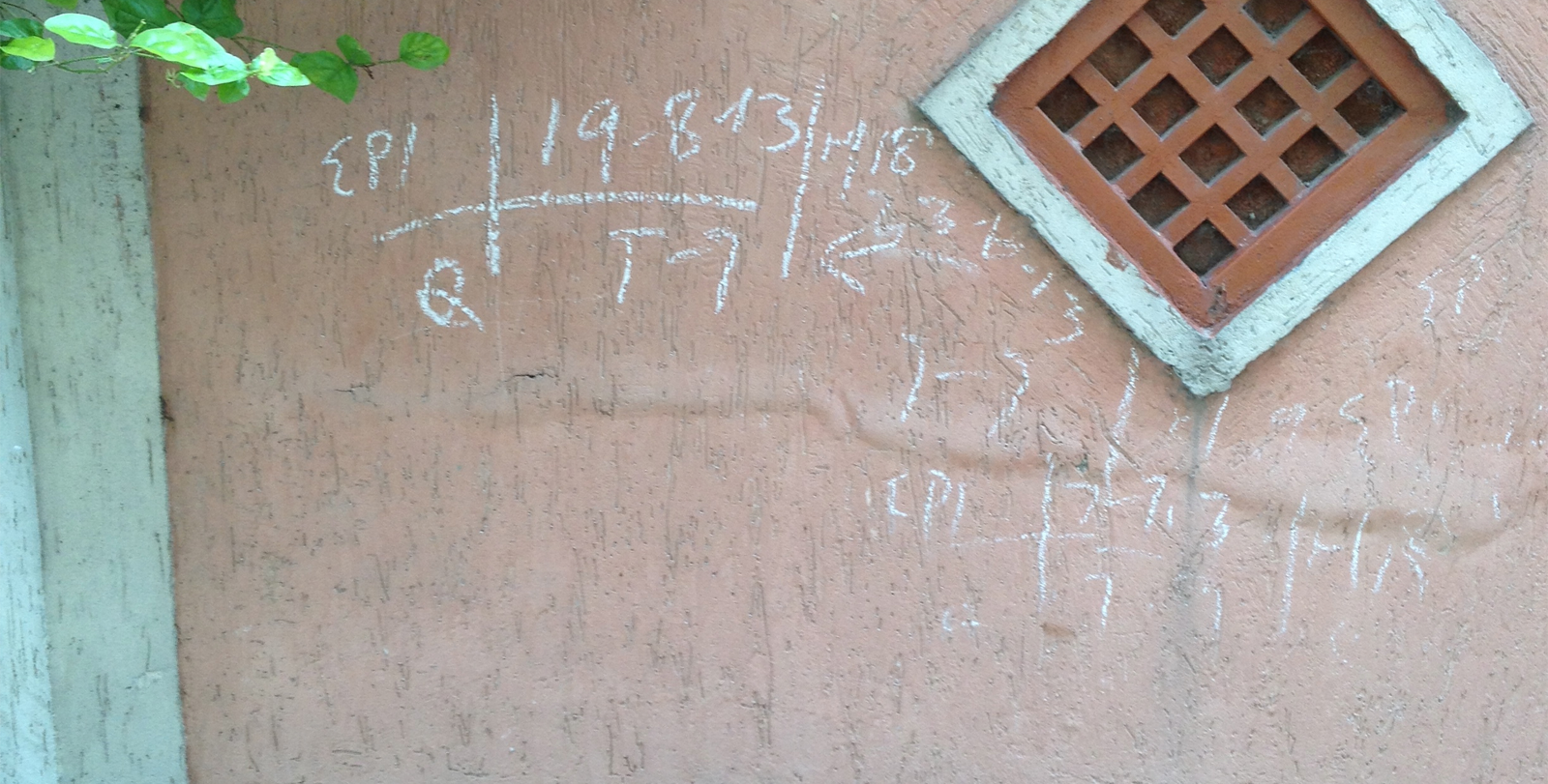 A photo of a stucco exterior wall of a house with chalk markings on it