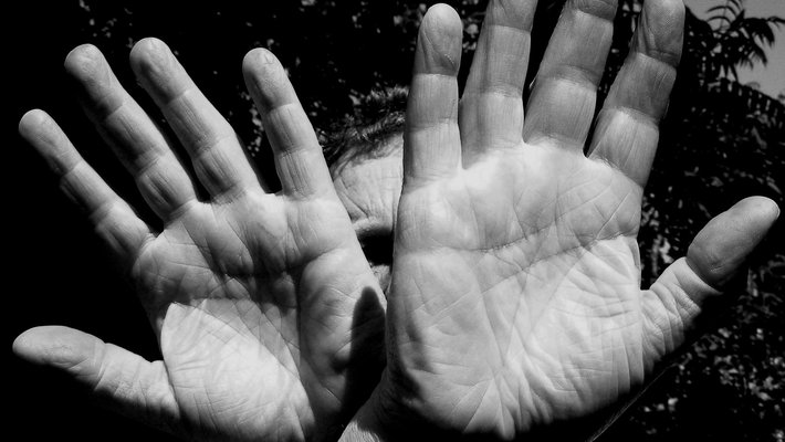 A black and white photo of two hands, palms facing the camera