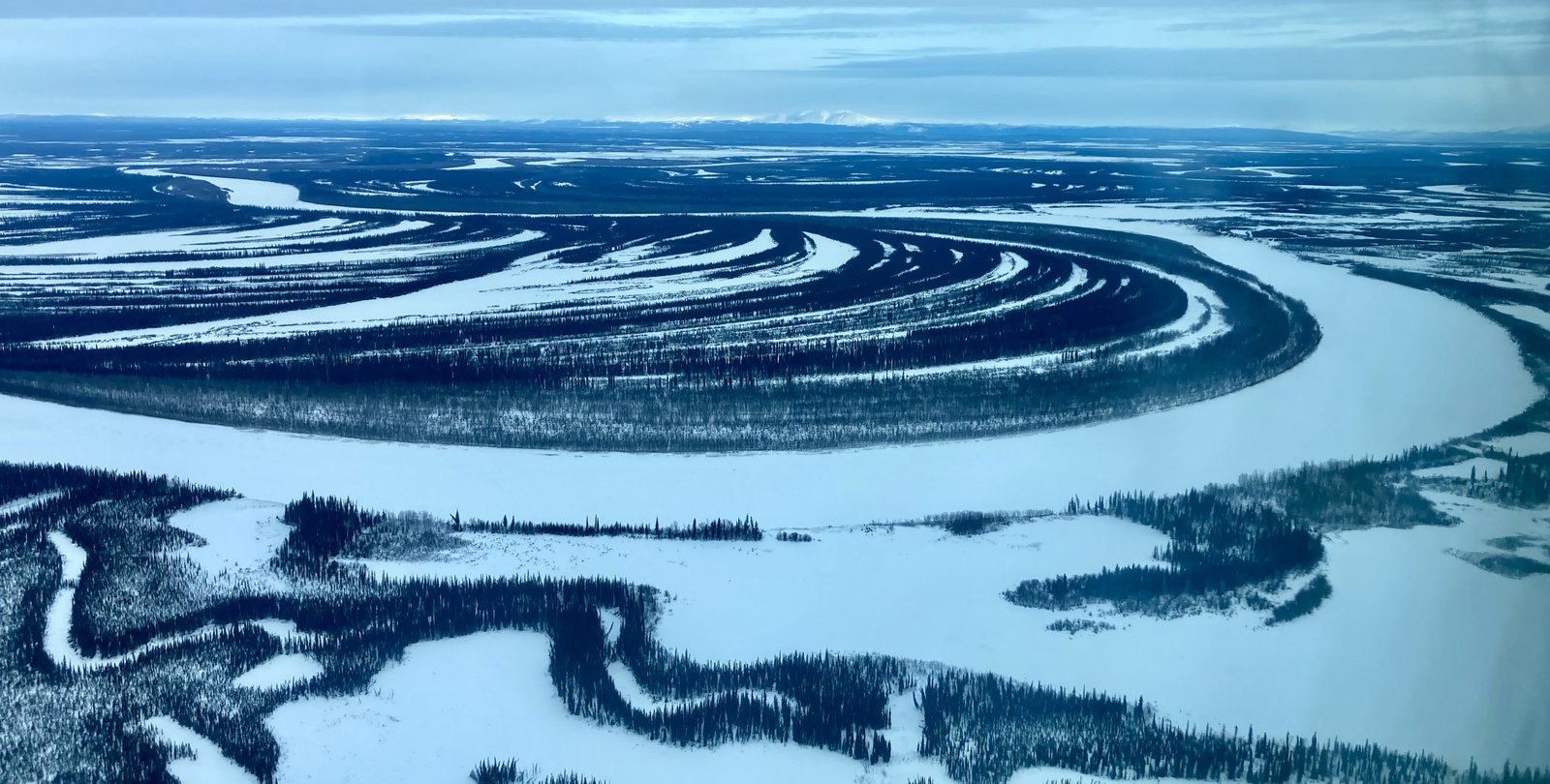 A dark blue river along white ground