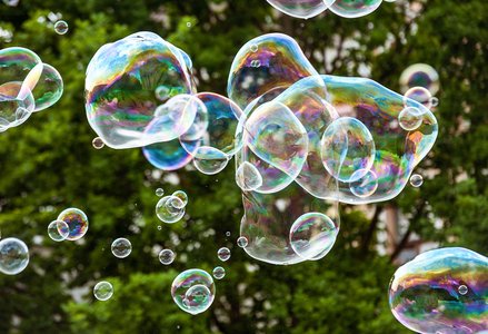 Photo of several colorful soap bubbles floating in the air