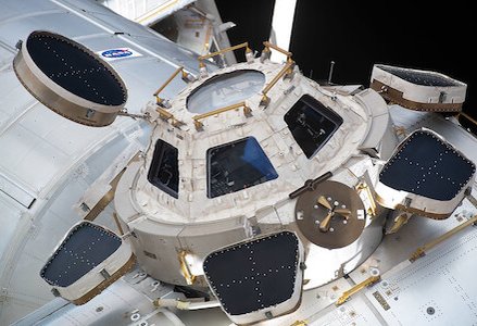 The Cupola module on the ISS has seven windows, offering panoramic Earth and space views. The detailed photo highlights its structure and NASA logo.