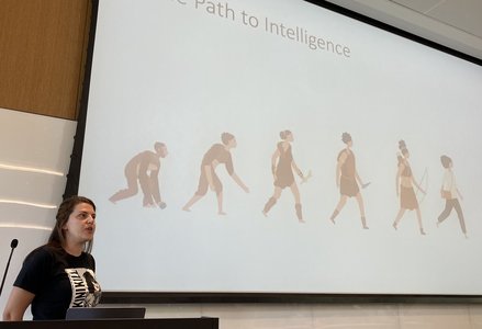professor in front of projector screen with the text 'path to intelligence' showing evolutionary patterns of human