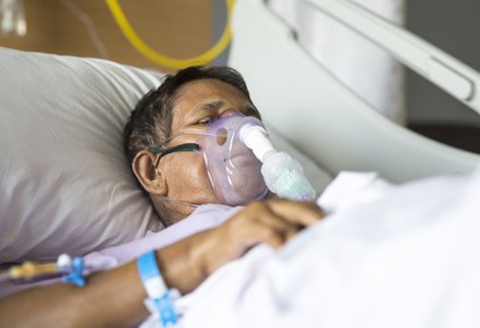 Patient in hospital bed with ventilator