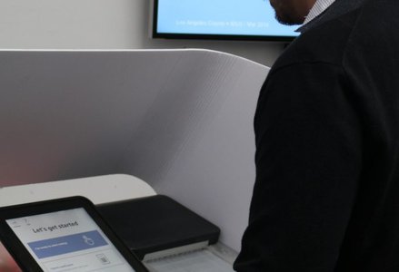 Man standing at electronic voting booth