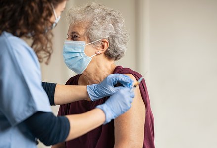 Older woman receives vaccine shot