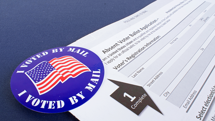 image of an I voted by mail sticker with American flag in the corner of a mail-in ballot