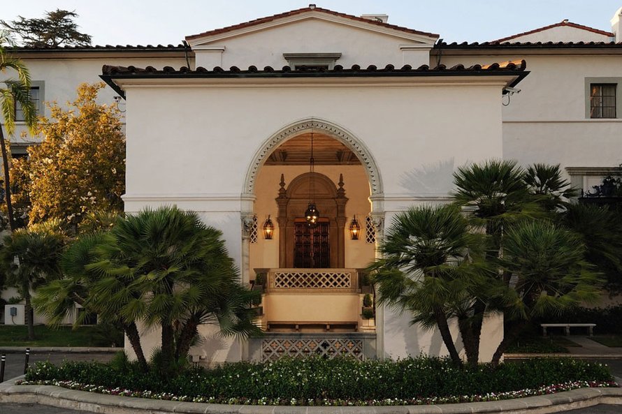 The Athenaeum's entry archway surrounded by palms and plants.